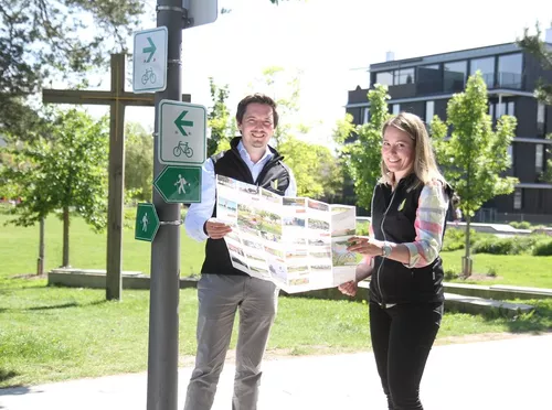 KUS-Vorstand Johannes Hofner und Projektmanagerin Lisa Sutter halten eine neue Wanderkarte in den Händen